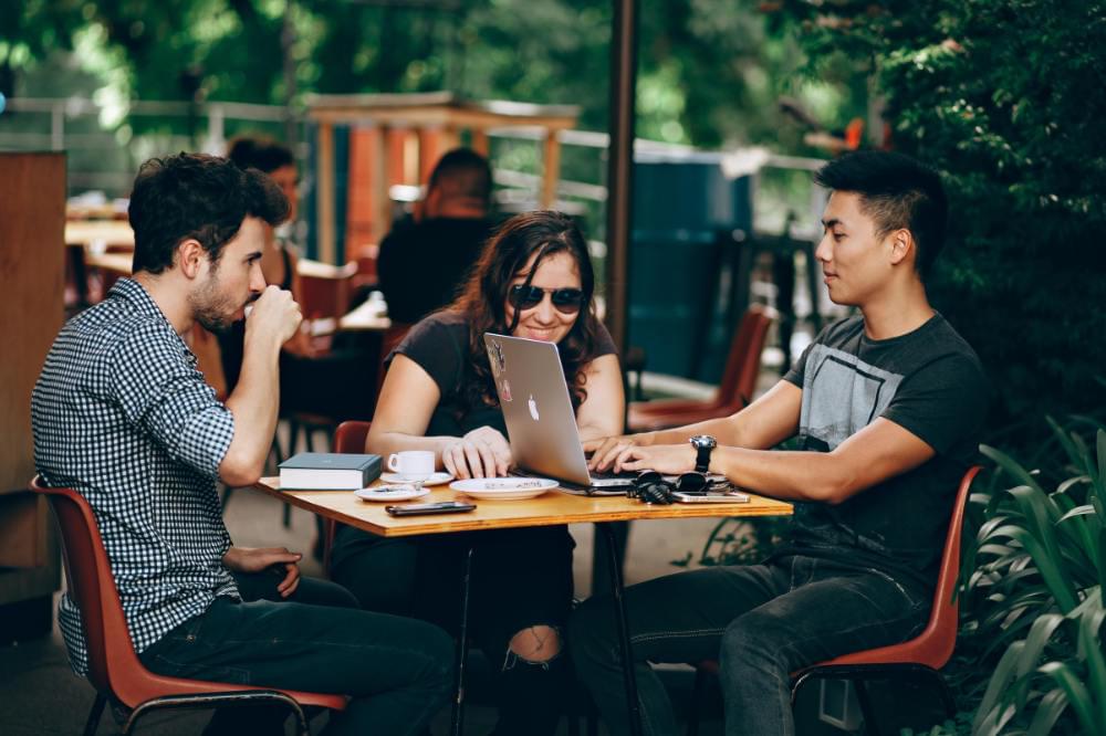 people sitting at table with laptop